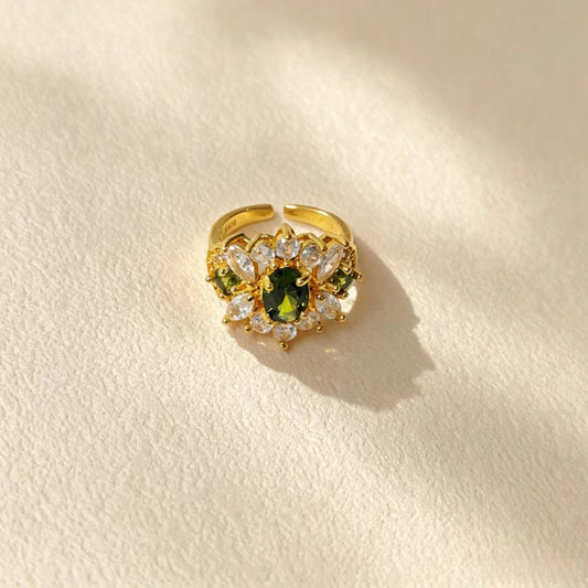 Gold plated copper adjustable open ring with green oval CZ stone, vintage floral design on off white background