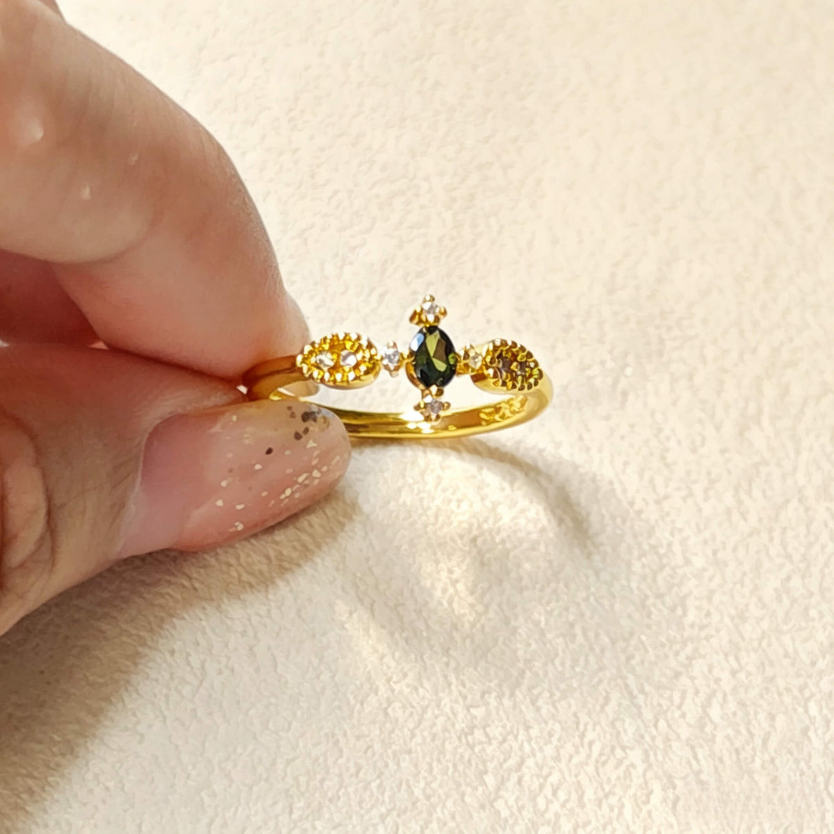 Close-up shot of vintage floral gold adjustable ring with oval green cubic zirconia, dainty copper cocktail women jewelry