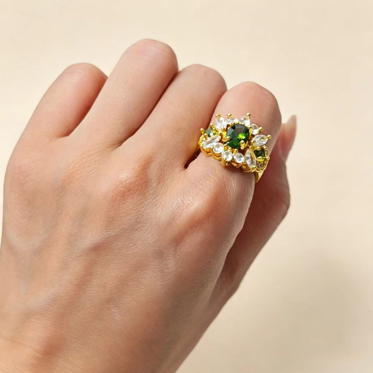 Hand wearing vintage floral copper ring with green CZ, showcase wearing effect
