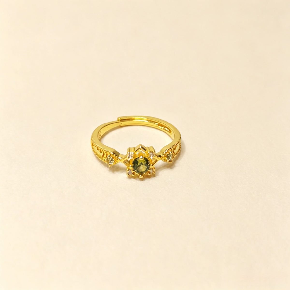 Vintage copper adjustable open ring with green inlaid stone on light beige background
